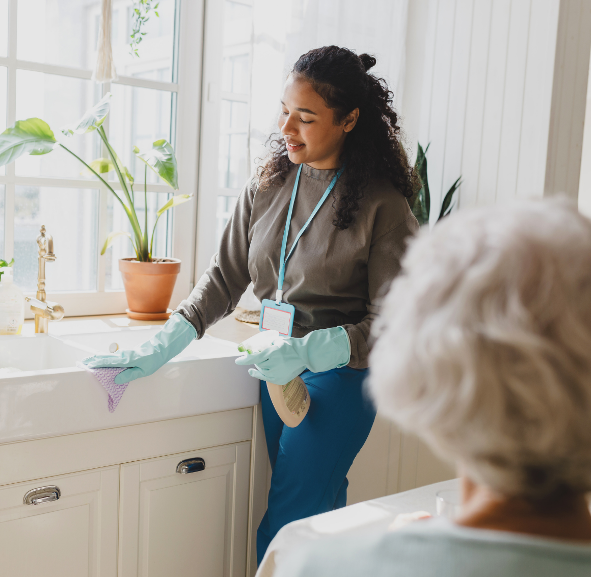 caregiver-cleaning-kitchen-sink-for-senior-client